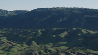 AX70_102 - 4K aerial stock footage Flyby green hills beside mountains in springtime, Gilroy, California