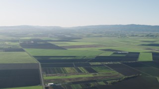 AX70_103 - 4K aerial stock footage Fly over crop fields beside a country road in Hollister, California