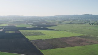AX70_106 - 4K stock footage aerial video Flying over large crop fields to approach Bolsa Road in Hollister, California
