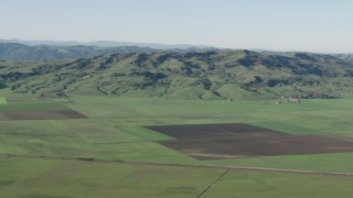AX70_107 - 4K aerial stock footage of farm fields and hills in Hollister, California