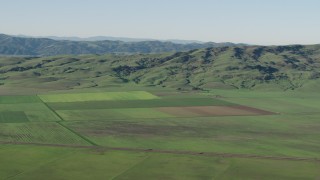 AX70_108 - 4K stock footage aerial video Farm fields beside green hills in Hollister, California
