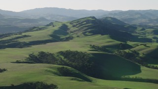 AX70_117 - 4K aerial stock footage An approach to green hills in Hollister, California