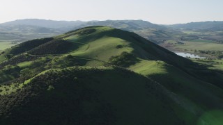 AX70_129 - 4K aerial stock footage Approach the top of a green hill in Hollister, California