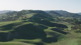 AX70_141 - 4K aerial stock footage A view of green hills with trees in Paicines, California