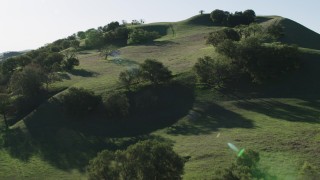 AX70_144 - 4K aerial stock footage Fly over trees toward a hilltop in Paicines, California