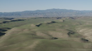AX70_165 - 4K aerial stock footage Passing rolling green hills in San Benito County, California
