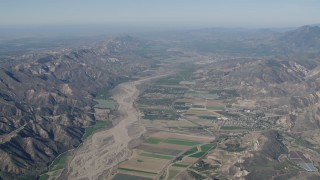 AX70_185 - 4K stock footage aerial video Flyby farm fields and Santa Clara River surrounded by mountains in Piru, California