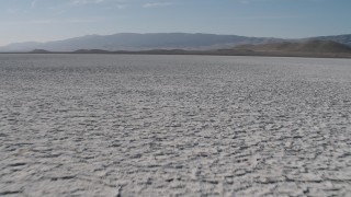 AX70_217 - 4K stock footage aerial video Fly low over Soda Lake in California, to approach desert mountains