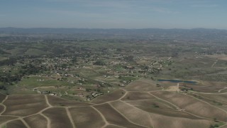 AX70_224 - 4K aerial stock footage Passing rural homes, vineyards, and a pond in Paso Robles, California