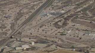 AX70_236 - 4K aerial stock footage Approach working oil rigs beside train tracks in San Ardo, California