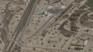 AX70_237 - 4K aerial stock footage Bird's eye of working oil rigs beside railroad tracks in San Ardo, California