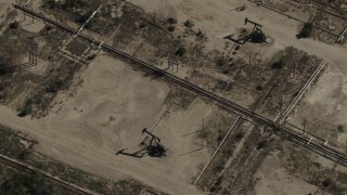 AX70_240 - 4K aerial stock footage Reverse view of a small group of oil rigs in San Ardo, California