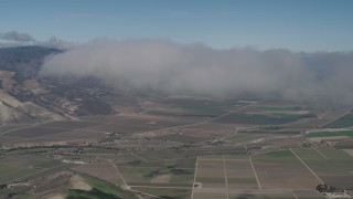 AX70_243 - 4K aerial stock footage of An approach to a cloud over farm fields in Greenfield, California
