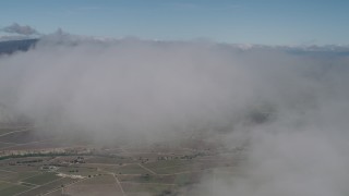 AX70_244 - 4K aerial stock footage Fly through a cloud over farm fields in Greenfield, California
