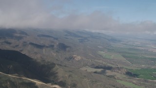 AX70_263 - 4K aerial stock footage fly over Santa Lucia Range mountain slopes and farmland in Soledad, California