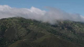 AX70_273 - 4K aerial stock footage of cloud-capped green mountains in the Santa Lucia Range in California