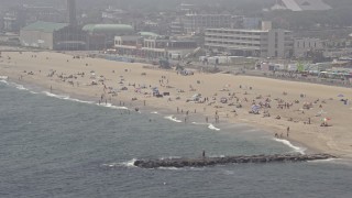AX71_064E - 5.1K aerial stock footage of beach goers on a foggy day in Asbury Park, Jersey Shore, New Jersey