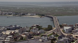 AX71_214 - 5.1K aerial stock footage of JFK Memorial Bridge, waterfront homes, and marshes in Longport, New Jersey