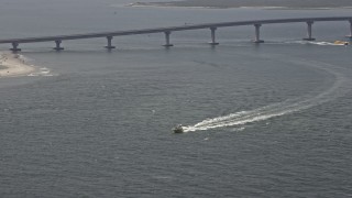AX71_216 - 5.1K aerial stock footage of a fishing boat speeding across Great Egg Harbor Inlet near Ocean Drive Bridge, Ocean City, New Jersey