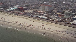 AX71_221 - 5.1K aerial stock footage of beach goers near Playland's Castaway Cove, Ocean City, New Jersey