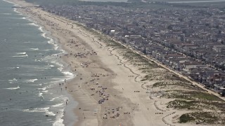 AX71_228E - 5.1K aerial stock footage of a populated beach and beachfront neighborhoods in Ocean City, New Jersey