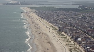 AX71_231 - 5.1K aerial stock footage of sunbathers enjoying the beach near oceanfront homes in Ocean City, New Jersey