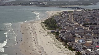 AX71_245E - 5.1K aerial stock footage flying over beach goers by beachfront homes near Townsends Inlet Bridge in Sea Isle City, New Jersey