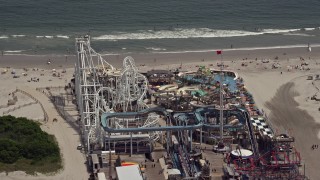 AX71_259E - 5.1K aerial stock footage of roller coasters at Surfside Pier in North Wildwood, New Jersey
