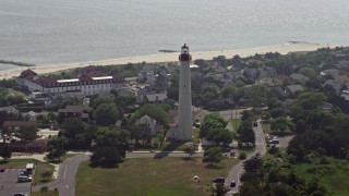 AX72_010 - 5.1K aerial stock footage of Cape May Lighthouse and coastal neighborhoods by the beach, New Jersey