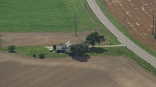 AX72_058 - 5.1K aerial stock footage of a farmhouse beside a country road in Frederica, Delaware