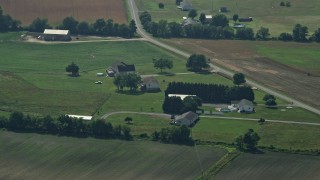 AX72_099 - 5.1K aerial stock footage of rural homes by a country road in Henderson, Maryland