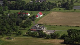 AX72_127 - 5.1K aerial stock footage of a large farmhouse, fields, and barns in Stevensville, Maryland