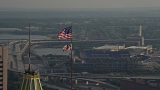 AX73_089 - 5.1K stock footage aerial video orbiting American and Maryland flags, Downtown Baltimore, Maryland