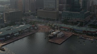 AX73_130 - 5.1K stock footage aerial video of USS Constellation and the Pratt Street Pavilion in Downtown Baltimore, Maryland