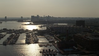 AX73_145 - 5.1K aerial stock footage of boats docked at the Baltimore Marine Center by riverfront office buildings, Maryland
