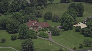 AX74_010 - 4.8K aerial stock footage of a lone upscale home with green lawns in Clifton, Virginia