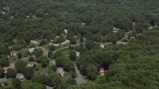 AX74_011 - 4.8K aerial stock footage flying by suburban homes and lush green trees in Clifton, Virginia