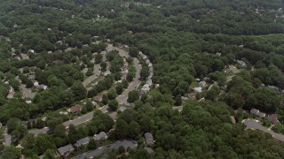 AX74_012E - 4.8K aerial stock footage flying over suburban homes and green trees in Fairfax, Virginia