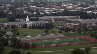 AX74_048 - 4.8K aerial stock footage of Charles Young Elementary School beside a high school football field in Washington D.C.