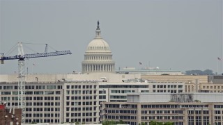 AX74_089E - 4.8K aerial stock footage of United States Capitol Dome seen above office buildings in Washington DC