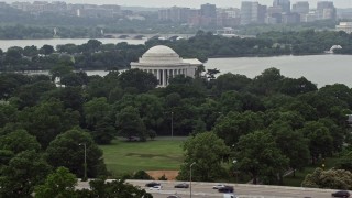 AX74_093 - 4.8K aerial stock footage of the Jefferson Memorial partially hidden by trees in West Potomac Park in Washington DC