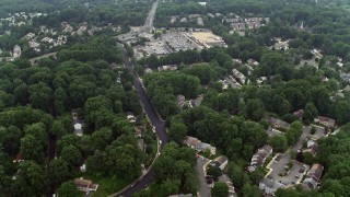 AX74_136E - 4.8K aerial stock footage flying over suburban homes to approach Burke Town Plaza in Burke, Virginia