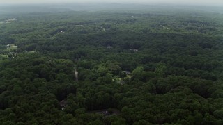 AX74_141E - 4.8K aerial stock footage flying over forest with a few upscale homes in Fairfax Station, Virginia