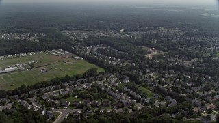 AX75_001E - 4.8K aerial stock footage flying by suburban neighborhoods. and fairground, Manassas, Virginia