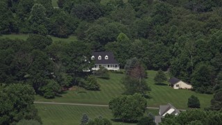 AX75_012 - 4.8K aerial stock footage of an isolated home partially hidden by trees in Clifton, Virginia
