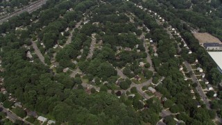 AX75_023E - 4.8K aerial stock footage of a bird's eye view of suburban homes and tree-lined streets, reveal shops in Springfield, Virginia