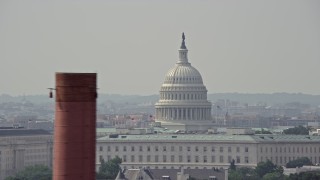 AX75_053E - 4.8K stock footage aerial video of United States Capitol dome visible above office building rooftops in Washington DC