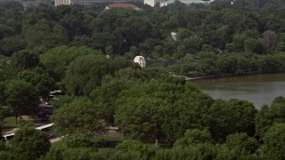 AX75_081 - 4.8K aerial stock footage flying by trees to reveal Martin Luther King Jr. National Memorial in Washington DC