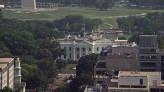 AX75_111E - 4.8K aerial stock footage of the White House seen over office building rooftops, reveal Washington Monument in Washington DC