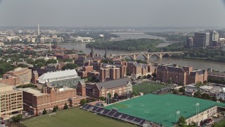 AX75_118E - 4.8K aerial stock footage of riverfront campus of Georgetown University, and sports fields in Washington DC